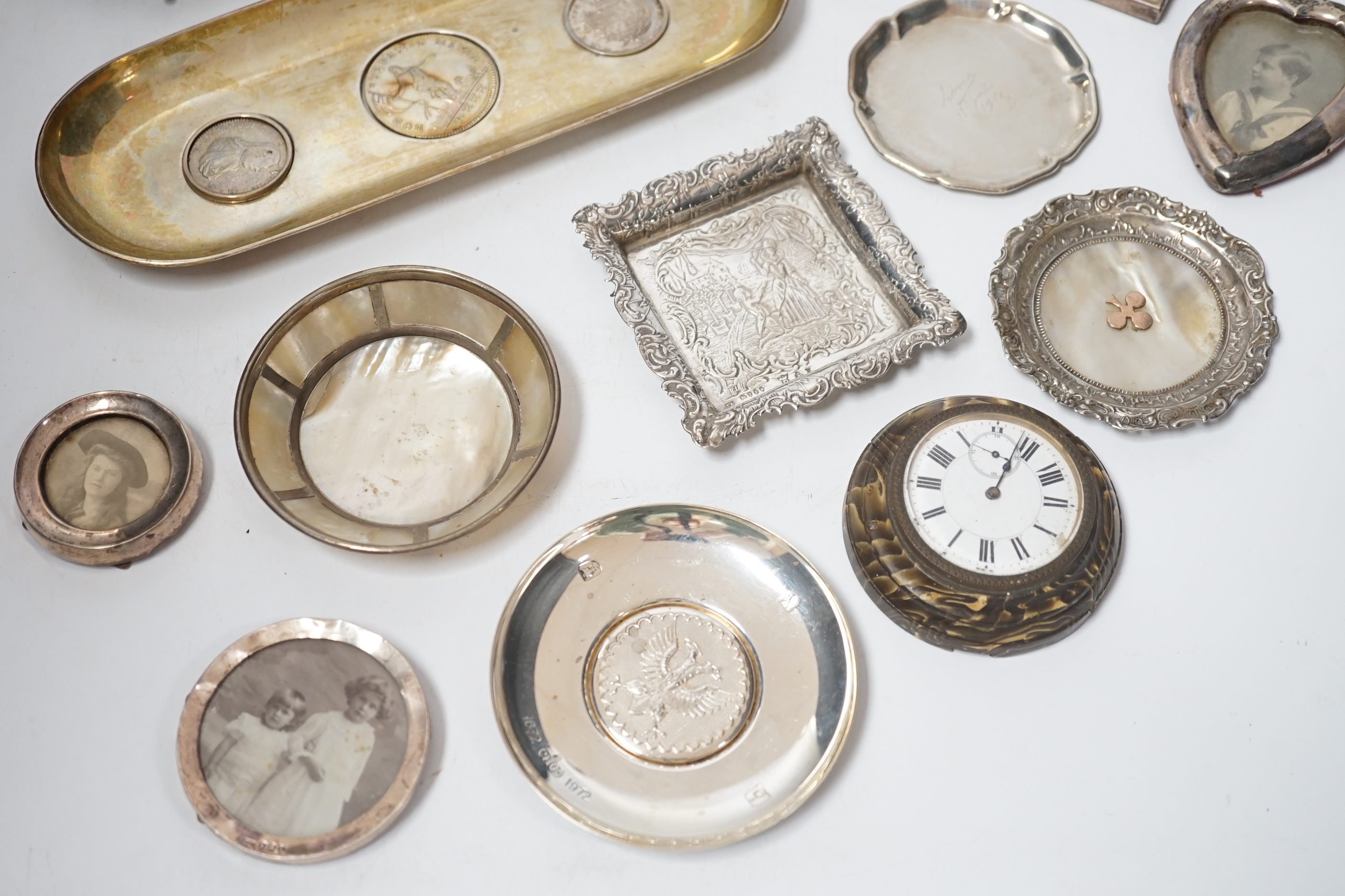 Sundry small silver and white metal items including seven photograph frames, largest 12.5cm, an 800 standard oval dish, inset with three coins, five small dishes and a timepiece.